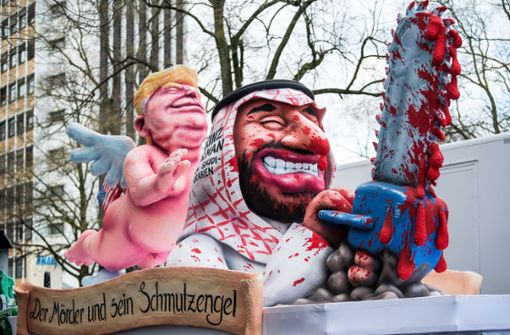 Düsseldorfs Karnevalisten zeigen den US-Präsidenten als nackigen „Schmutzengel“, der seine schützende Hand über einen mit blutiger Kettensäge ausgestatteten Prinz Salman von Saudi-Arabien hält. Foto: Getty Images Europe
