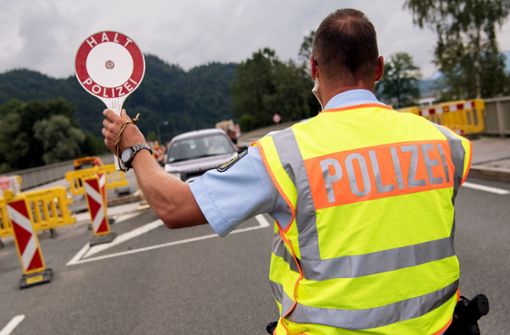 Polizisten kontrollieren an einer mobilen Kontrollstelle kurz hinter der Grenze Fahrzeuge, die aus Österreich nach Deutschland kommen. Foto: dpa/Sven Hoppe