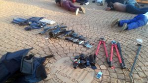 Einige Tatverdächtige liegen nach dem Polizeieinsatz auf dem Boden. Foto: dpa