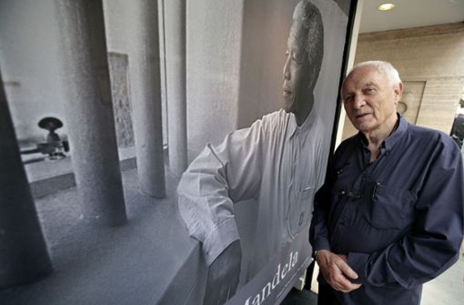 Der Fotograf Jürgen Schadeberg vor einem Plakat mit einer seiner Aufnahmen Nelson Mandelas Foto: AFP/Shaun Curry
