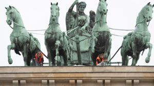 Zwei Klima-Aktivisten sind aufs Brandenburger Tor geklettert. Foto: dpa/Paul Zinken