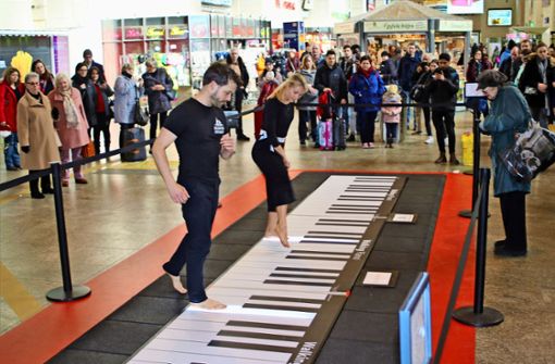Dennis Volk und Leslie Lynn tanzen auf dem Walking Piano für die Reisenden in der Bahnhofshalle. Die beiden Künstler wollen den Zuschauern eine Auszeit vom Alltag verschaffen. Foto: Julia Schenkenhofer