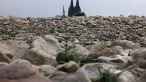 Es wird  einsam um die Kirche: Der Kölner Dom ragt hinter Steinen im ausgetrockneten Flussbett des Rheins empor.  Mehr als eine halbe Million Menschen sind 2022 aus der katholischen Kirche ausgetreten, wie die Deutsche Bischofskonferenz (DBK) mitteilte. Foto: dpa/Oliver Berg