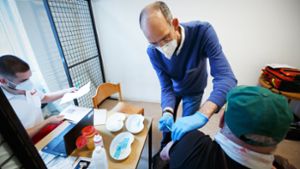Der Hautarzt Ralf Denfeld setzt die Spritze bei einem Bewohner der Zentralen Notübernachtung. Foto: Lichtgut/Leif Piechowski