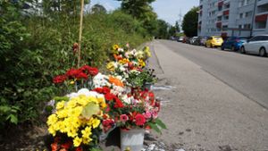 Nachbarn legen am Tag nach dem Mord am Tatort Blumen für das Opfer nieder. Foto: Andreas Rosar (Archiv)
