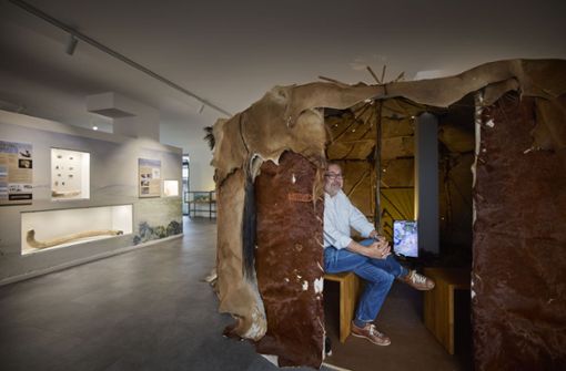 Wolfram Hammer sitzt in der Steinzeit-Jurte aus Fell, in der ein digitales Lagerfeuer brennt. Foto: Gottfried Stoppel