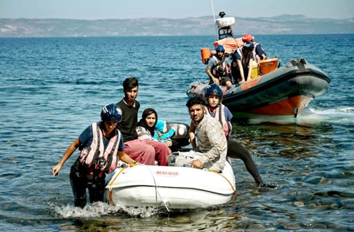 Flüchtlingshelfer nehmen eine Asyl suchende Familie in Empfang, die auf der griechischen Insel Lesbos anlandet. Foto: AFP