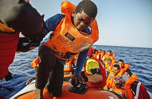 Dieses Kind und die Männer im Schlauchboot sind vor der libyschen Küste von einer Nichtregierungsorganisation gerettet worden. Foto: AP