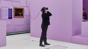 Eine Frau schaut sich die Ausstellung „Kunst als Beute“ mit VR-Brille im Humboldt-Forum an. Foto: © 2020 by Alexander Schippel