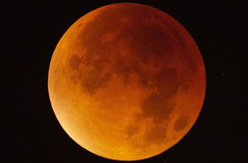 Der Mond erscheint am 21. Januar über Stuttgart während einer Mondfinsternis fast vollständig in einem rötlichen Farbton. Ursache des roten Schimmers sind die roten Anteile des Spektrums der Sonnenstrahlen, die durch die Erdatmosphäre in den Kernschatten der Erde abgelenkt werden. Foto: dpa