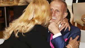 Angelika Camm-Daum umarmt ihren zu Tränen gerührten Mann Christoph Daum nach seiner zutiefst emotionalen Rede bei der Gedenkfeier für MV in der Mercedes-Benz-Arena. Foto: / Wolfgang List