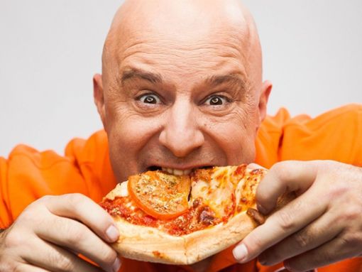 Detlef Steves beißt genüsslich in eine Pizza: Der Reality-TV-Star war viele Jahre übergewichtig. Jetzt hat er neun Wochen lang streng Diät gemacht. Foto: VOX/Guido Lange