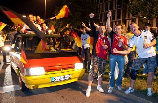 Anhänger der deutschen Fußballnationalmannschaft feiern auf der Theodor-Heuss-Straße den WM-Auftaktsieg gegen Australien.   Foto: dpa