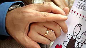 Ein frisch vermähltes Ehepaar hält seine Heiratsurkunde in den Händen. Foto: dpa