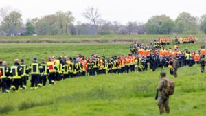 Soldaten der Bundeswehr und Einsatzkräfte von Feuerwehr und Polizei stellen sich auf, um ein Feld abzusuchen. Foto: dpa/Bodo Marks