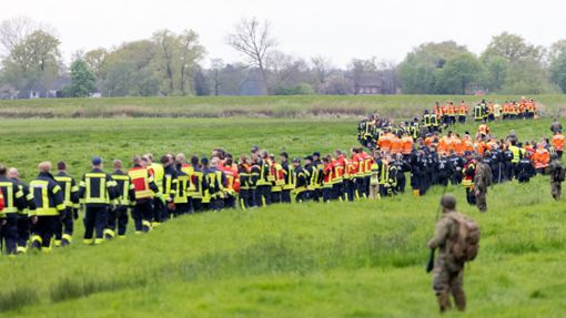 Soldaten der Bundeswehr und Einsatzkräfte von Feuerwehr und Polizei stellen sich auf, um ein Feld abzusuchen. Foto: dpa/Bodo Marks