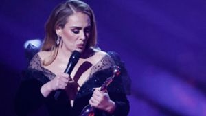 Sichtlich gerührt: Sängerin Adele mit einem ihrer drei Brit Awards. Foto: AFP/TOLGA AKMEN