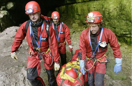 Höhlenretter simulieren in der Falkensteiner Höhle bei Grabenstetten die Bergung einer verletzten Person, die in einer flexiblen Trage aus der Höhle transportiert wird. Foto: dpa