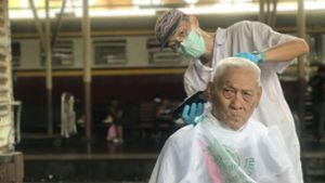 In Bangkok bekommen Bahnfahrer kostenlose Haarschnitte. Foto: dpa