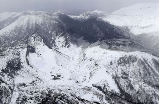 Asche des Vulkans Mount Kusatsu Shirane liegt am Dienstag neben dem Gipfel des Berges in der Nähe eines Skigebiets. Foto: Kyodo News/AP
