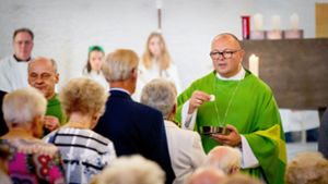 Weihbischof  Gerhard Schneider (re.)  beim Heiligen Abendmahl. Foto: Lichtgut/Julian Rettig