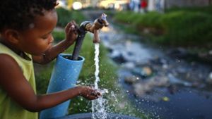 Ein Junge trinkt aus einer kommunalen Quelle in Kapstadt. Seit Monaten sind die Bewohner der südafrikanischen Metropole zum strengen Wassersparen angehalten. Foto:  