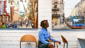 Die Kuratorin Elena Hocke sitzt zwischen zwei Stadtansichten der Ehninger Malerin Karin Allmendinger. Foto: Simon Granville