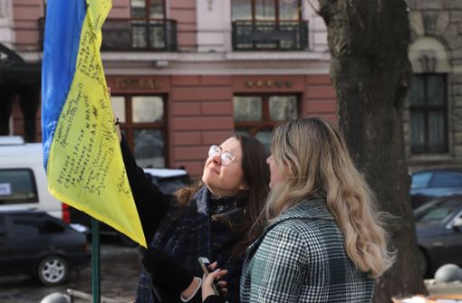Sofia Sidokova und Juliya Zaitseva, beide 19 Jahre alt,  bestaunen die Fahne, die irgendjemand unweit   der Staatsoper aufgestellt hat. Foto: StN/Feyder