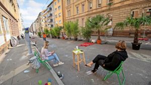 Erwachsene sitzen auf der Straße, Kinder spielen: Im Jahr 2021 wurde die Augustenstraße anlässlich der Stuttgarter Mobilitätswoche schon einmal zum „Superblock West“. Foto: Lichtgut//Leif Piechowski