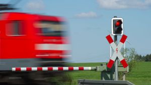 Halt! Ein Zug fährt bei  Jacobsdorf in Brandenburg an einem geschlossenem Bahnübergang mit Andreaskreuz und rotem Lichtsignal  vorbei. Foto: dpa/Patrick Pleul