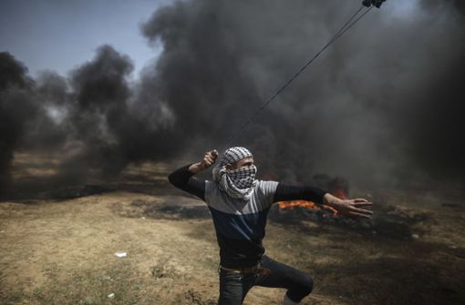 Ein Palästinenser schleudert bei Zusammenstößen zwischen palästinensischen Demonstranten und israelischen Soldaten im Gazastreifen Steine mit einer Schleuder. Foto: dpa
