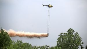 Per Helikopter wird Kalk über den Baumwipfeln  verteilt. Foto: Landratsamt
