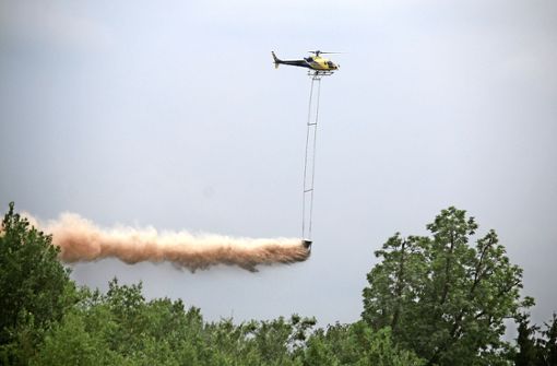 Per Helikopter wird Kalk über den Baumwipfeln  verteilt. Foto: Landratsamt