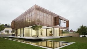 Wohnhaus mit Kupfervorhang über dem verglasten Erdgeschoss, geplant von Architekt Bernd Liebel. Dazu ein japanischer Kuchenbaum und ein Koi-Teich. Foto: Brigida González