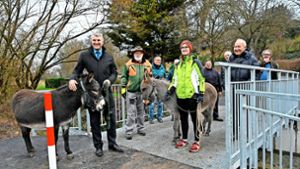 OB Schönberger und zwei Esel führen die Delegation zur Brückeneinweihung an. Foto: Peter Mann