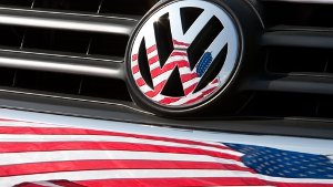 Die US-Fahne spiegelt sich  in Logo und Kühlergrill eines Autos der Marke VW.  Die  Abgasaffäre schadet dem Image von VW in den USA massiv. Foto: dpa