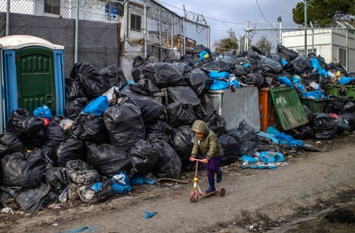 Ein Flüchtlingsjunge fährt mit einem Roller vor Müllsäcken im Flüchtlingslager Moria auf Lesbos. (Archivbild) Foto: dpa/Angelos Tzortzinis