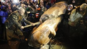 Bei erneuten Massenprotesten in Kiew haben Hunderttausende Anhänger der proeuropäischen Opposition um Vitali Klitschko mit Nachdruck einen Machtwechsel gefordert. Maskierte Unbekannte warfen am Rande der Demonstration dicke Stahlseile um eine Granitstatue von Revolutionsführer Lenin und stürzen das rund 3,50 Meter hohe Denkmal. Foto: dpa