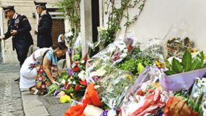 Eine Passantin legt Blumen für den toten Polizeibeamten nieder. Foto: dpa