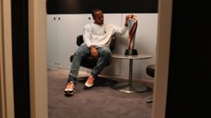 Rekordweltmeister Lewis Hamilton mustert in einer stillen Minute in einem Nebenzimmer den Pokal für den Sieger des Großen Preises der Türkei. Foto: imago/Motorsport Images