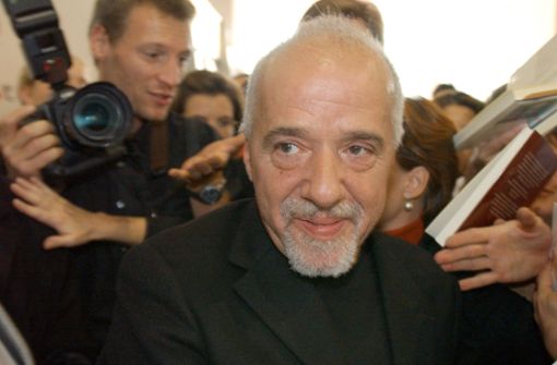 Umringt von Fans und Autogrammjägern bahnt sich der brasilianische Bestseller-Auto Paulo Coelho 2003 auf der Frankfurter Buchmesse einen Weg. Foto: dpa/Boris Roessler