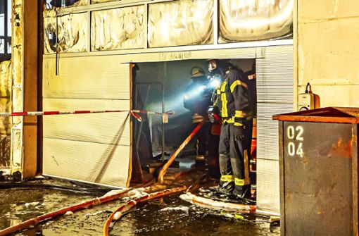 Feuerwehrleute in der zerstörten Halle der Schreinerei am 27. September in Stammheim Foto: 7aktuell/Alexander Hald