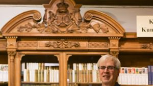 Geschäftsinhaber  in sechster Generation:  Gunnar Gräff in seinem Antiquariat  in der Calwer Straße vor einem Bücherschrank, der königlichen Ursprungs sein könnte. Foto: Lg/Max Kovalenko