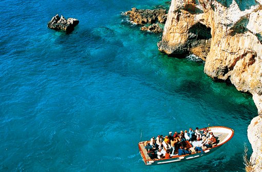 In Booten fahren Touristen zu den steilen Kalkfelsen. Foto: Brünjes