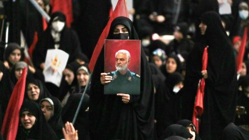 Eine Frau zeigt während einer Gedenkfeier  in der großen Imam-Khomeini-Moschee in Teheran ein Bildnis des 2020 im Irak getöteten Qassem Soleimani. Foto: Vahid Salemi/AP/Vahid Salemi