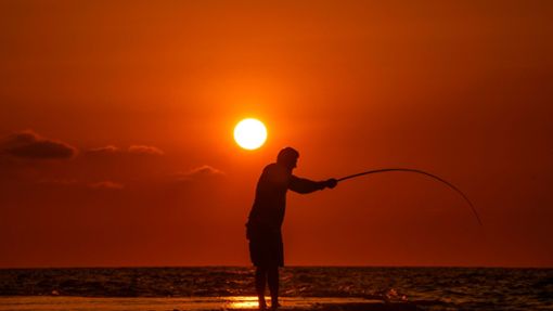Alltag im Libanon: Ein Fischer wirft seine Angel von einem felsigen Gebiet entlang der Küste von Beirut aus, während die Sonne über dem Mittelmeer untergeht. Foto: Hassan Ammar/AP/dpa