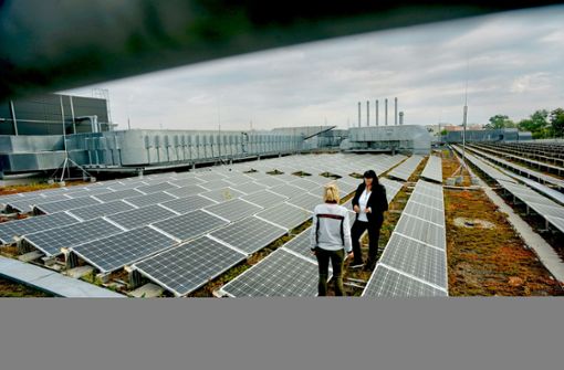 Anke Höller, die Umwelt- und Energiemanagerin von Porsche (rechts), erläutert die Vorteile  der Fotovoltaikanlage auf dem Dach des Motorenwerks. Foto: Lichtgut/Max Kovalenko
