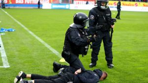 Die Polizei stoppt einen Ultra vom Fußball-Zweitligisten Holstein Kiel. Foto: Bongarts