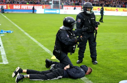 Die Polizei stoppt einen Ultra vom Fußball-Zweitligisten Holstein Kiel. Foto: Bongarts