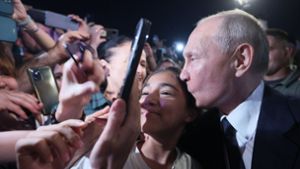 Kremlchef Putin nimmt in der russischen Kaukasusrepublik Dagestan ein Bild in der Menge und küsst ein Mädchen  auf die Schläfe Foto: dpa/Gavriil Grigorov
